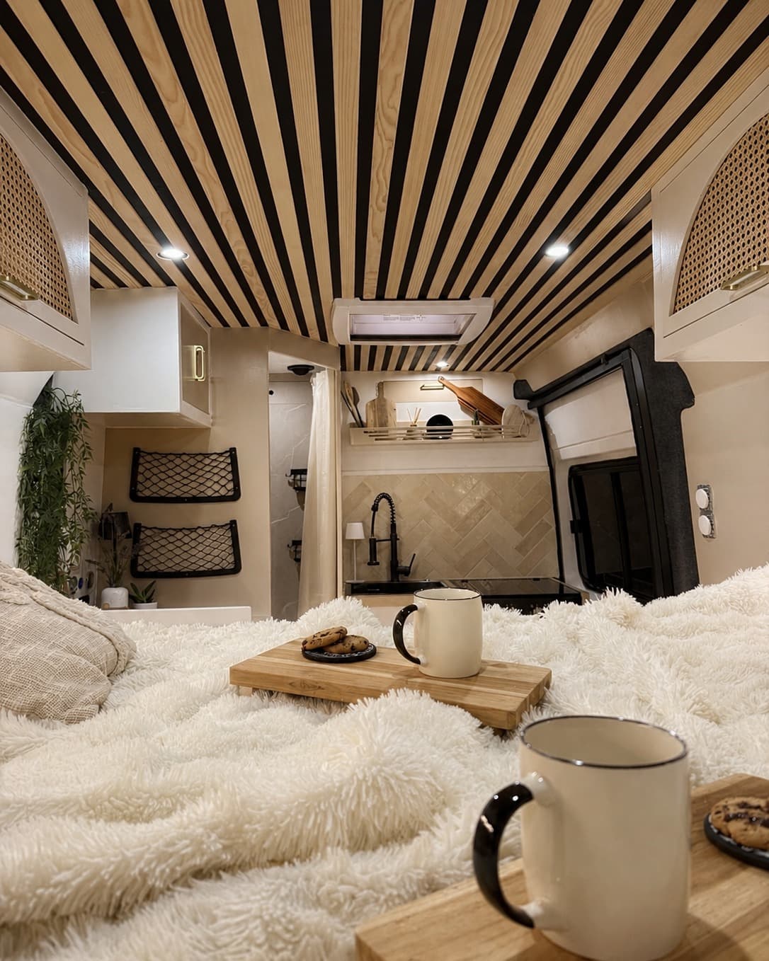 Intérieur d'un van Seven Vanlife, petit-déjeuner servi sur le lit